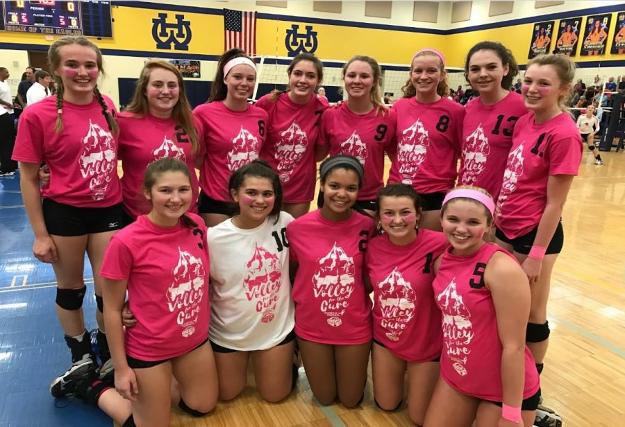 Volleyball team members play to raise money to research cures for cancer.