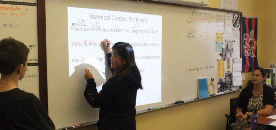 Two students work to diagram and deconstruct a Latin sentence with the guidance of Kathleen Keener. Latin, a fundamental part of the WHHS curriculum, is sometimes criticized as unnecessary and outdated. 