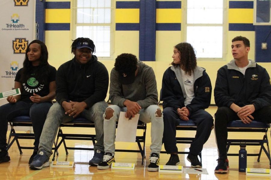 Our photo of the day shot by SENIOR Jonathan Brown showcases five of the ten seniors who signed to colleges this week for athletics. From the left, Alysea Jenkins signed to Roosevelt University for basketball, Ryan Mickens to Mount ST Joseph for football, Caleb Streat will be playing football for Tiffin University, and finally Augustana College will be welcoming Dominique Valentine and Isaiah Valentine (far right) for swimming. Congratulations to our seniors advancing their academic and athletic educations! 