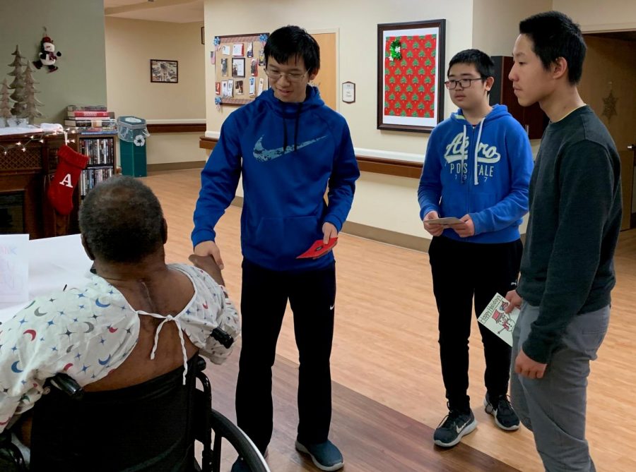 From left to right: Red Cross Club members Justin Chan, ‘22, Ben Liu, ‘22, and Bojun Fu, ‘22, shake hands with a veteran patient during their visit to the Veteran Association Medical Center. 
