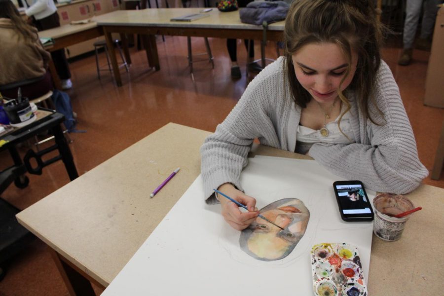 Alexandra Franz, ‘23, works on a self portrait during her AP Studio Art class, using a selfie for reference. Franz worked in watercolor, which she developed as her specialty this year. “A lot of people think [watercolor is] hard, but there’s a wildness to it that is fun to try to tame that I really enjoy,” Franz said.