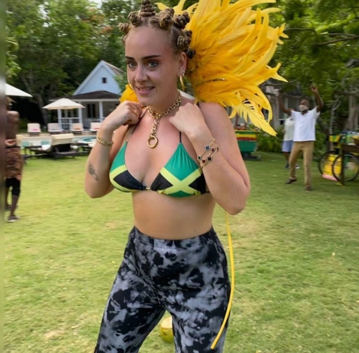 The photo that sparked a frenzy. Adele, pictured in a Jamaican Flag bikini, a yellow feather headdress, Bantu knots, and black and gray yoga pants, has become the center of a cultural storm after posting what she wore to Notting Hill Carnival in 2019 on Instagram.
