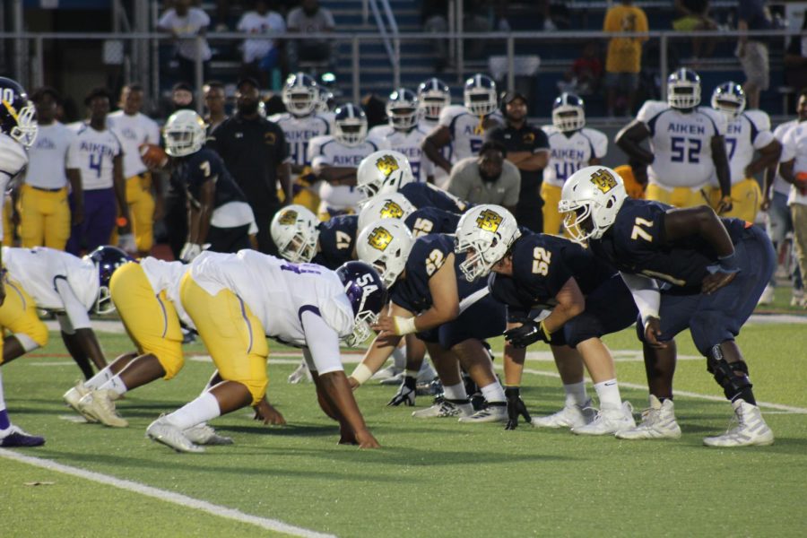 The WHHS defensive line stands countering the Aiken offensive line, waiting for the ball to be snapped during the game on Aug. 20. 