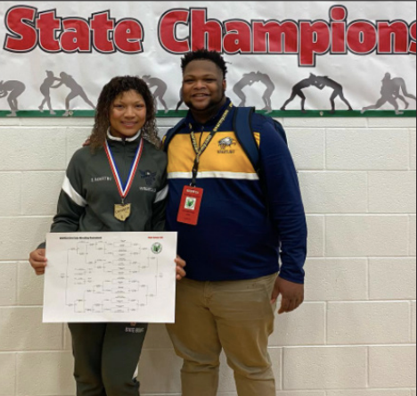 SENIOR Erin Martin poses with her coach Michael Francis after winning the state title in the 155 pound weight class wrestling state championship.