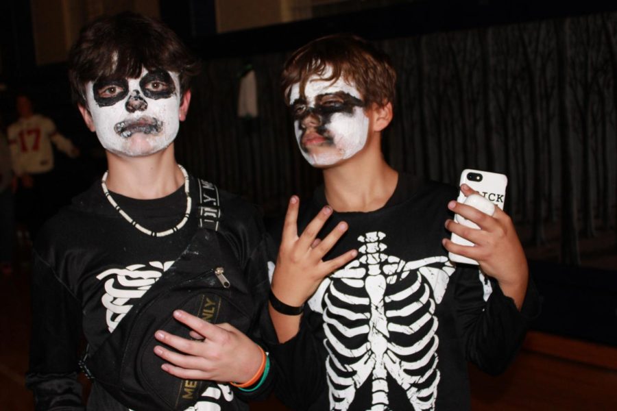 Two friends dressed as skeletons pose for the camera, enjoying the boogie bash to its fullest.