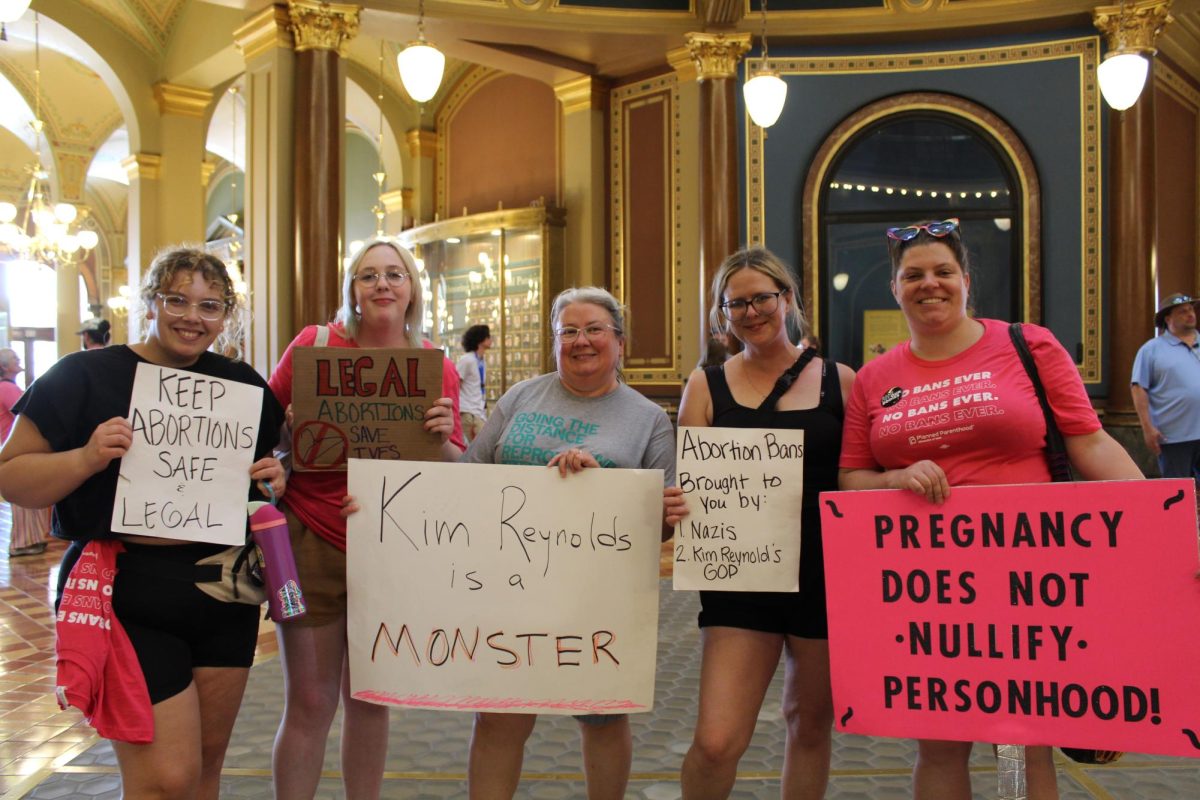 Pro-choice protesters at the Capitol hold signs like "Kim Reynolds is a Monster" and "Legal Abortions Save Lives". 