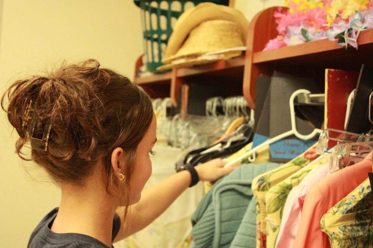 Amelia Price, '27, put costumes away in the womens’ dressing room to keep them safe for future theater performances. 