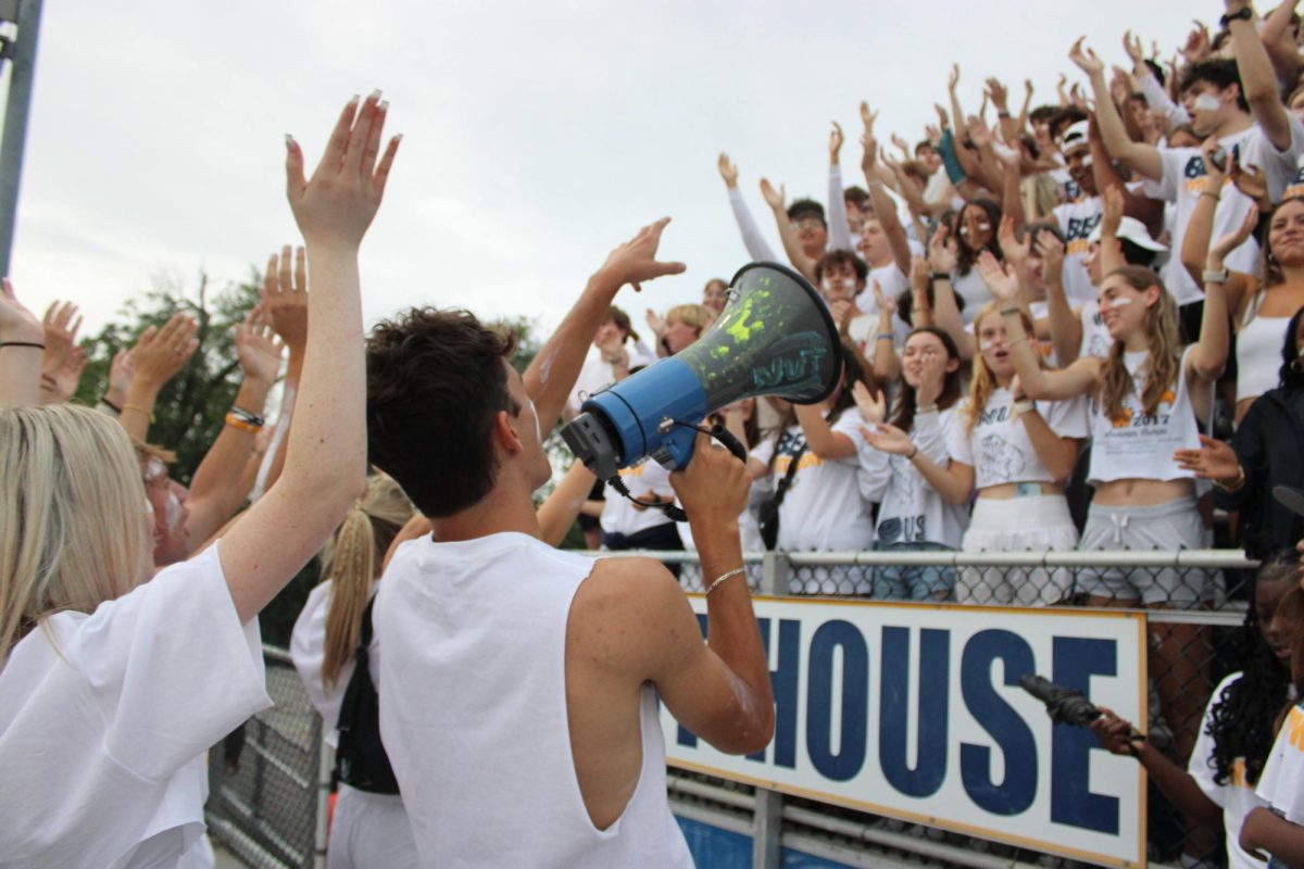 Liam Garth, ‘24, leads the Nuthouse in a chant in the first football game of the season against Withrow. 
