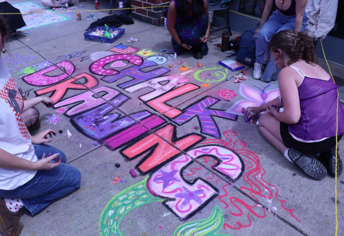 Students draw on the ground at the chalk drawing competition.
