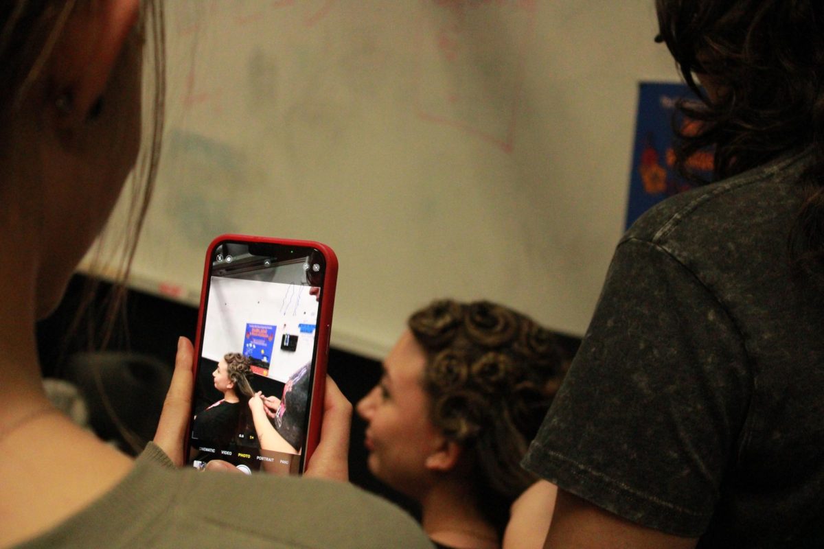 Lauryn Shafer, ‘26, takes photos of Aunna Phillips, ‘29, getting her hair done by Piper Hawkins, ‘29.