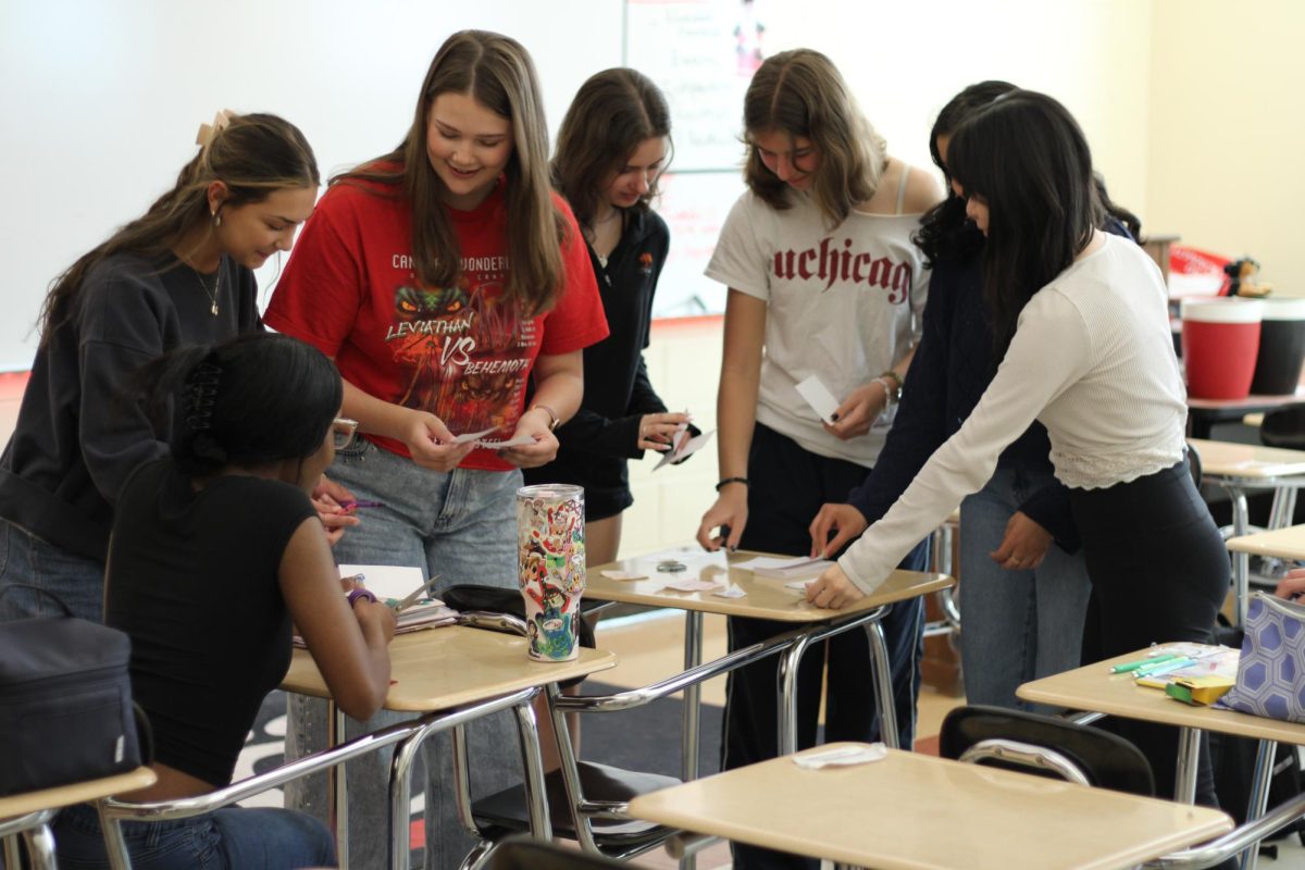 Members of Stellar Wonderz work together to create cards to stick on the windshields of cars. 