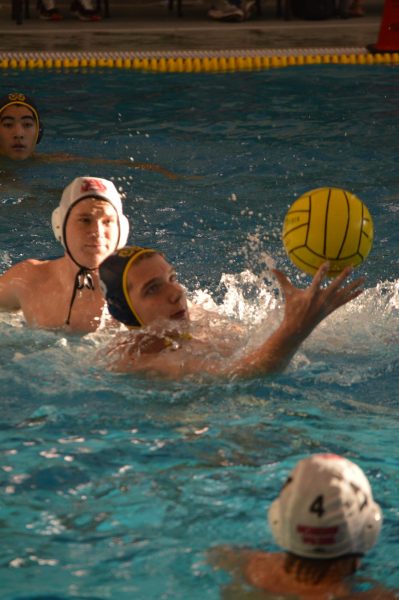 Ernie Manders, '26, grasps the water polo ball during a match.