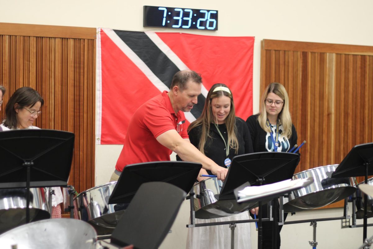 Faculty steel drum band director, Edward LeBorgne, helps teachers Nicole Pennekamp and Angela Schnormeier.